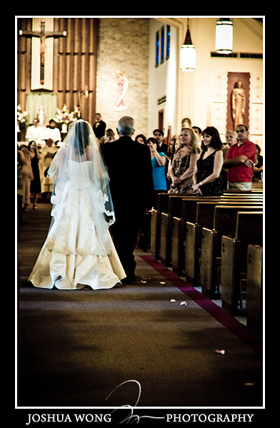 The bride is escorted down the aisle. Holy Family Roman Catholic Church in Fresh Meadows wedding photos by Josh Wong Photography 