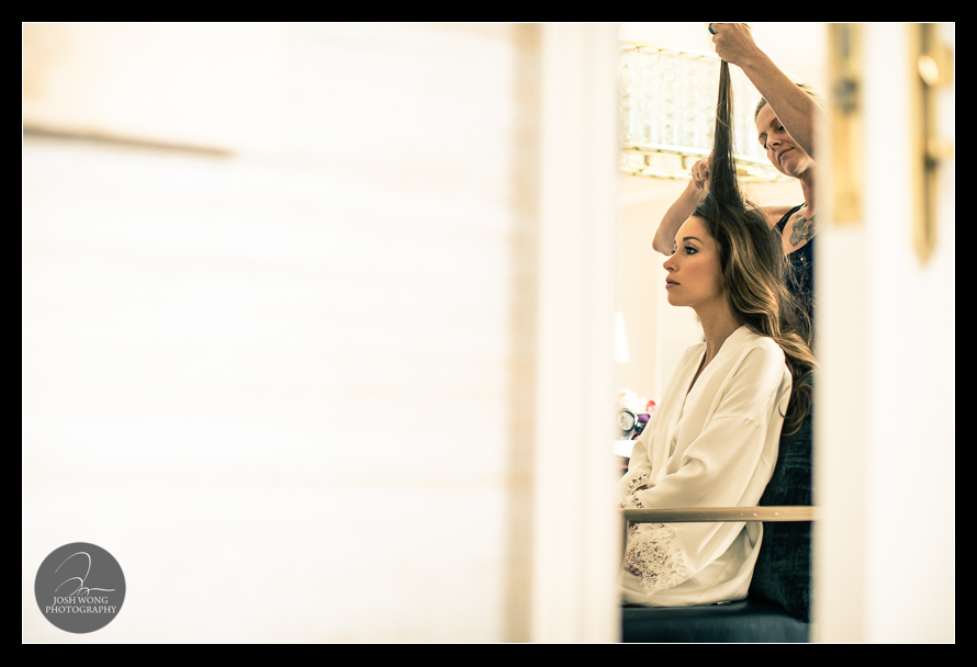 A peek through the ajared door of the bride getting her hair done.  JW Marriott Essex House Wedding. Wedding Pictures and photos provided by Josh Wong Photography, New York City