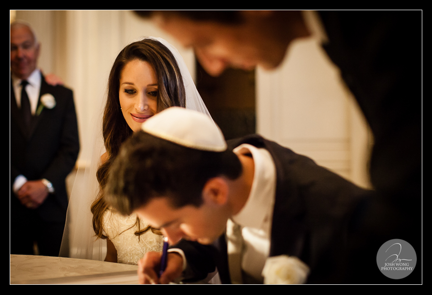 The bride admires her groom signing the Ketubah right before the ceremony. images by Jewish wedding photographer Josh Wong Photography - Essex House Wedding photos