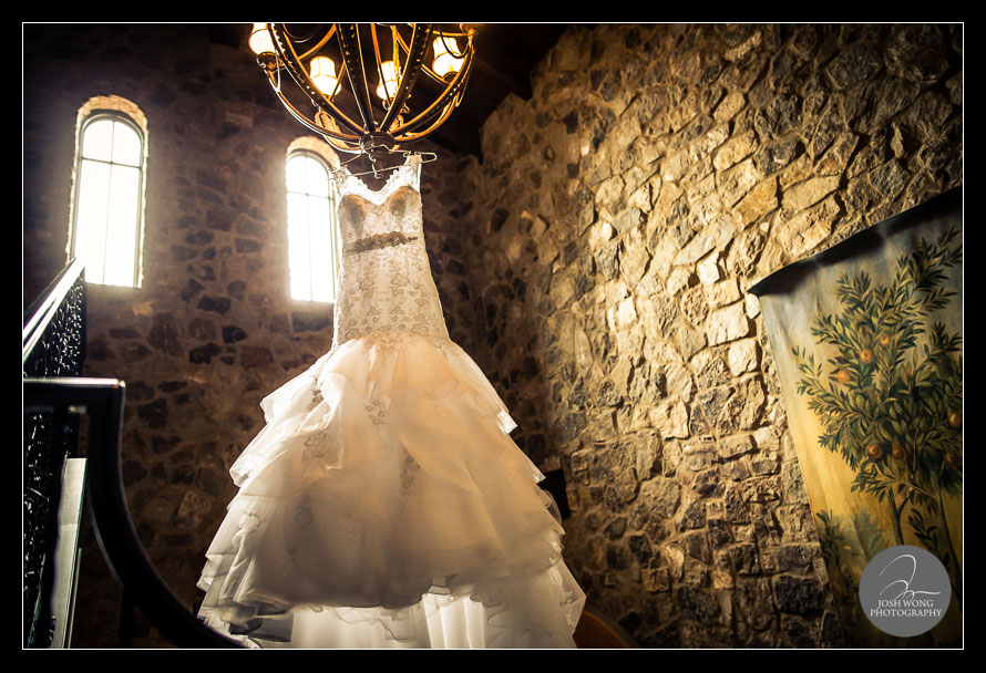 The wedding dress drapes off of the chandelier in the castle tower outside of the Bella Collina Bridal Suite. A Bella Collina wedding by top Florida Wedding Photographer Josh Wong Photography