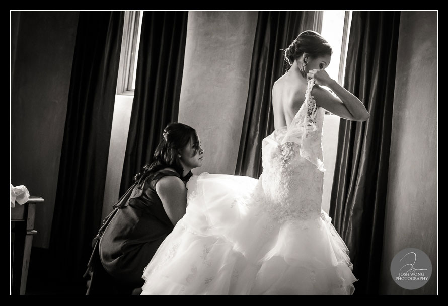 The bride getting dressed into her dress . Bella Collina wedding photos taken by top Florida Wedding Photographer Josh Wong Photography.