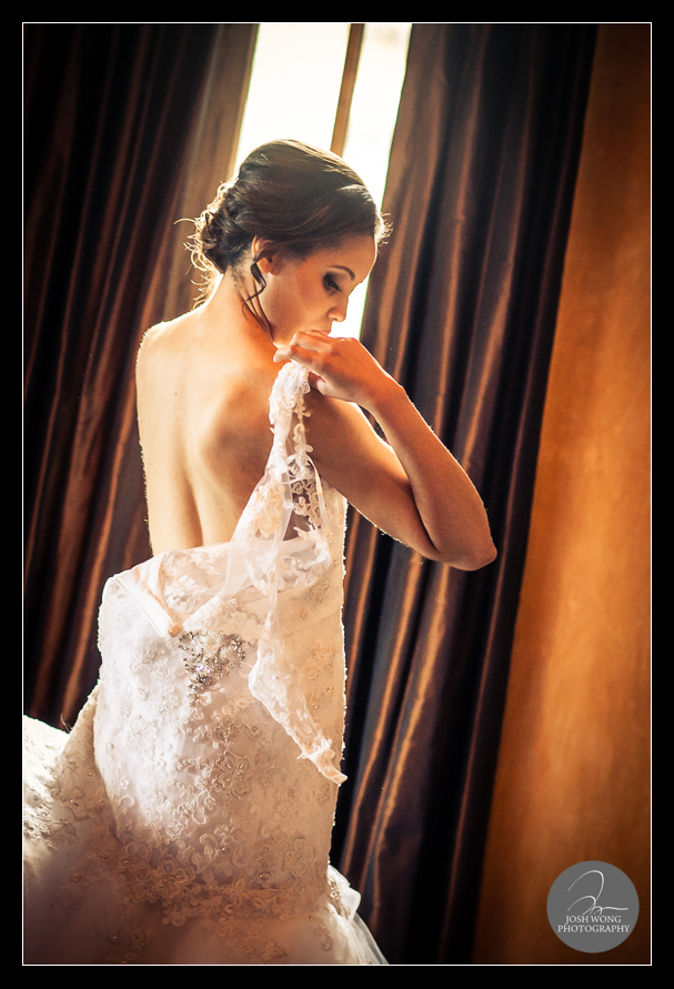 The bride getting dressed into her dress . Bella Collina wedding photos taken by top Florida Wedding Photographer Josh Wong Photography.