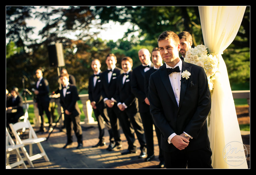 The groom watch his bride walk down the aisle.