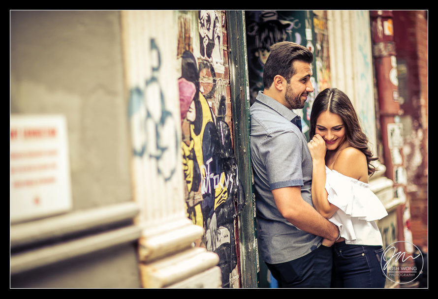 The couple sit in front of the NYC Love Wall in Soho.