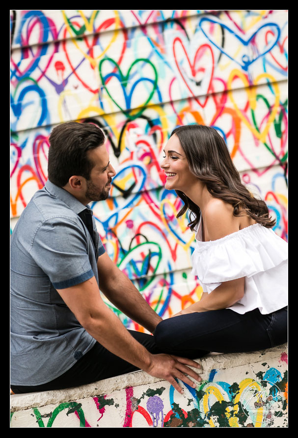 The couple sit in front of the NYC Love Wall in Soho.