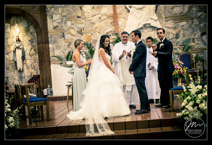 A Maria Regina Church in Massapequa NY Wedding Ceremony. The Bride and Groom smile at each other. Best candid wedding photos happen during the ceremony. Wedding pictures by Top New York Wedding photographers Josh Wong Photography