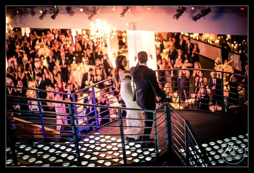 The bride and groom descend the grand staircase of the wedding venue.