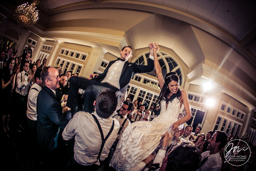 The newlywed are lifted up in the chairs. A Jewish tradition during the Hora Dance.