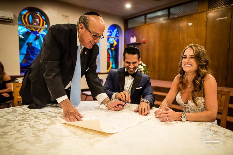 The best wedding candid moments are at the signing of the Ketubah. Jewish wedding at the Temple of Israel in Lawrence, NY by top New York Wedding Photographers Josh Wong Photography