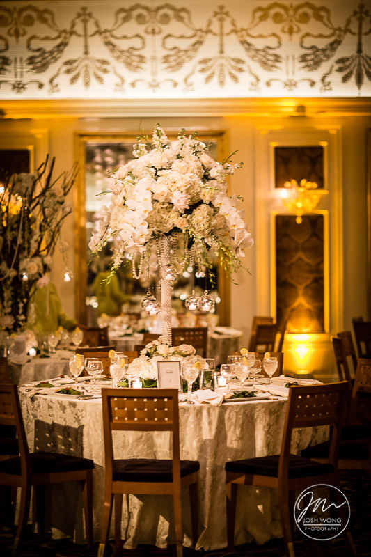 The lovely wedding table floral centerpiece with tall floral flutes. 