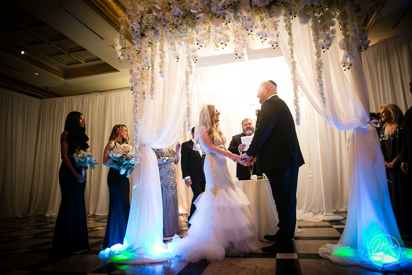 In the moment with the bride and groom exchanging nuptials. Best wedding candid moments at The Venetian in Garfield, NJ. Wedding photos by Josh Wong Photography