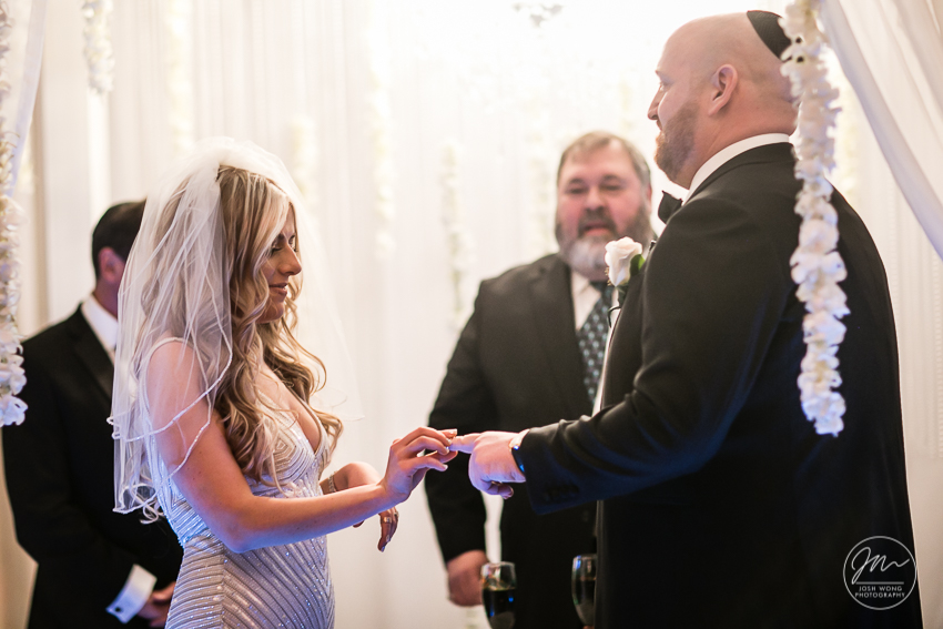 In the moment with the bride and groom exchanging their rings. Best wedding candid moments at The Venetian in Garfield, NJ. Wedding photos by Josh Wong Photography