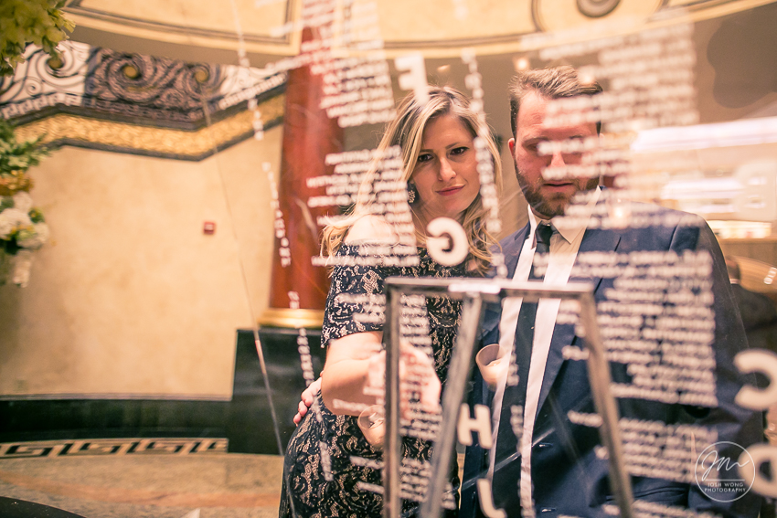 Guest find their seating assignment on the tempered glass seating chart.  Best wedding candid moments at The Venetian in Garfield, NJ. Wedding photos by Josh Wong Photography