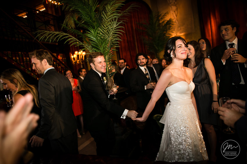 The bride and groom enter the Jane Hotel Ballroom to a crowd of family and friends cheering. The Jane Hotel wedding pictures by Josh Wong Photography