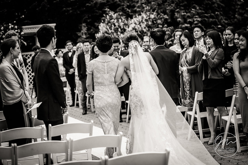In the moment. The parents of the bride escort their daughter down the aisle.