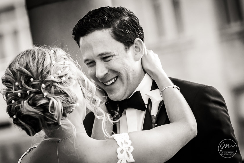 An emotional bride reveals herself to the groom. The "First Look" on the balcony of the bridal suite at Marriott East Side, New York City. Wedding pictures by top NYC wedding photographer Josh Wong.