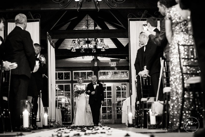 The Father of the bride escorts the bride down the aisle. Wedding photography by NYC wedding photographer Josh Wong. Central Park Boathouse.
