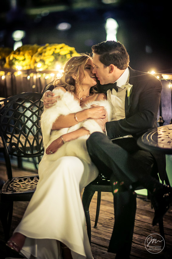 The beautiful couple embrace in the cool fall weather at Central Park's iconic boathouse.
