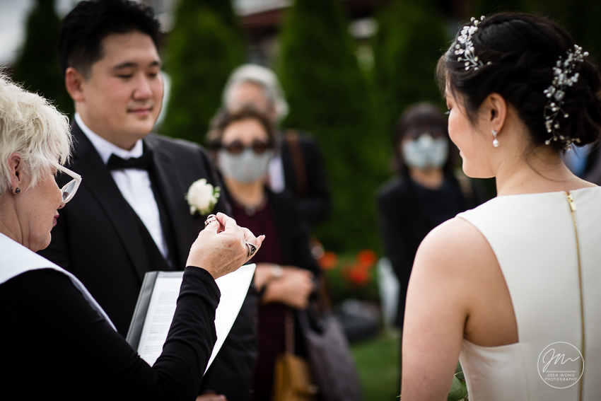 The wedding officiant holds the wedding rings and explains the ring's significance. Photo by Josh Wong Photography