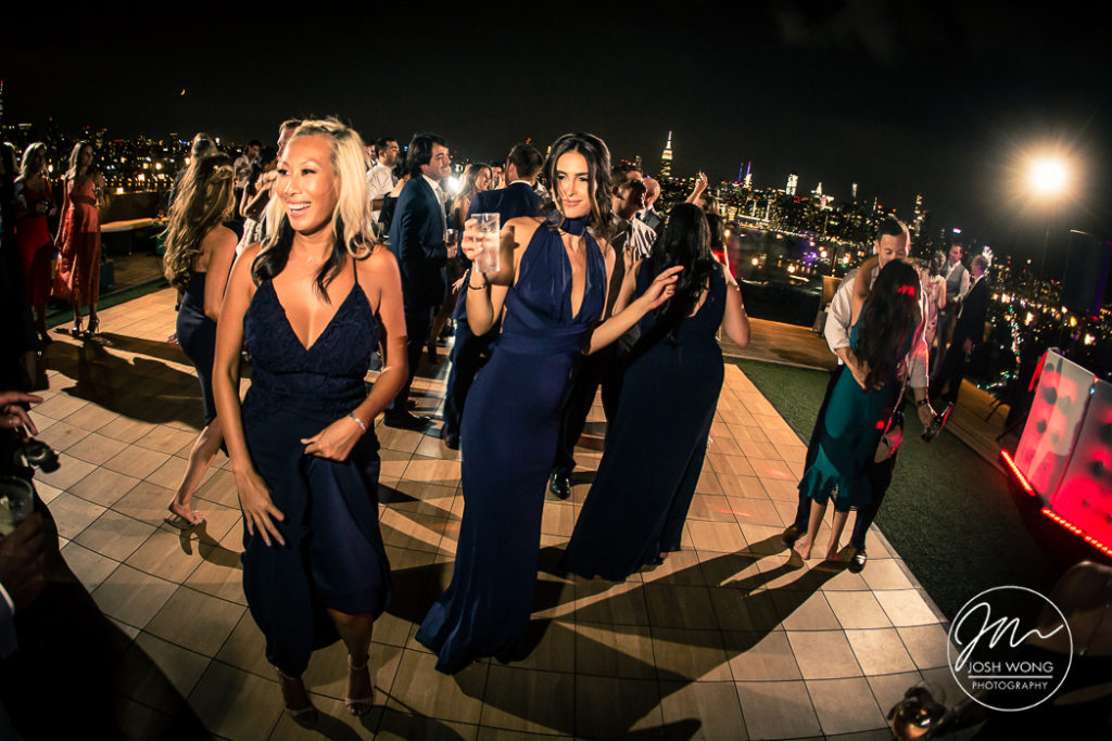 The rooftop night scene as guest dance the night away at The William Vale. Wedding photos by Brooklyn Wedding Photographer Josh Wong Photography