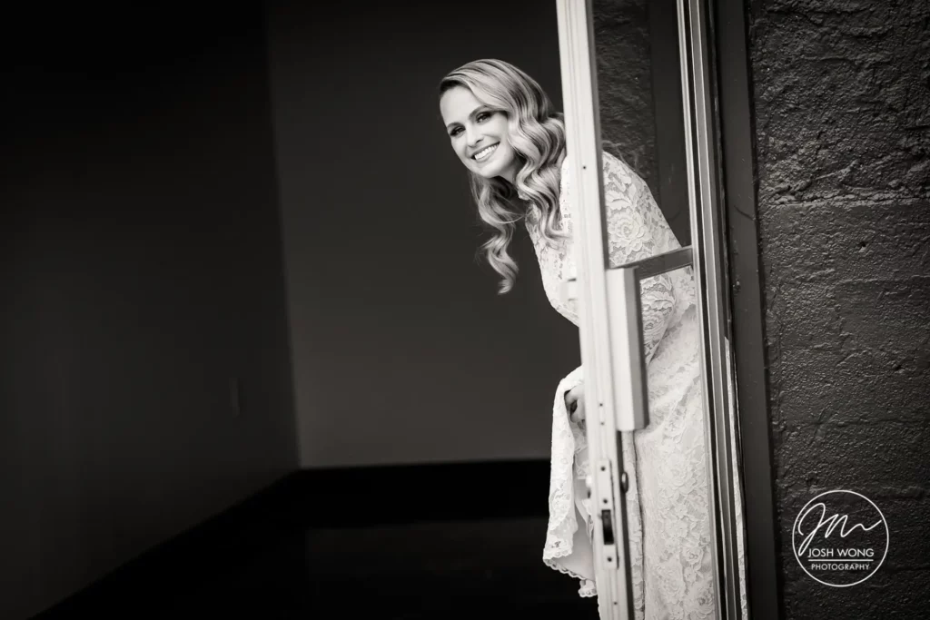 The bride peers out to see where her groom is standing in anticipation of the first look. photo by Josh Wong Photography