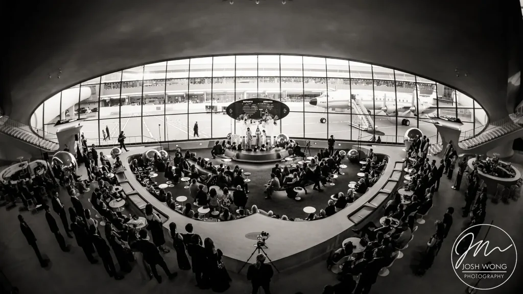 TWA Hotel Wedding ceremony in the Sunken Lounge hanger at JFK Airport. Wedding photographer by Josh Wong Photography